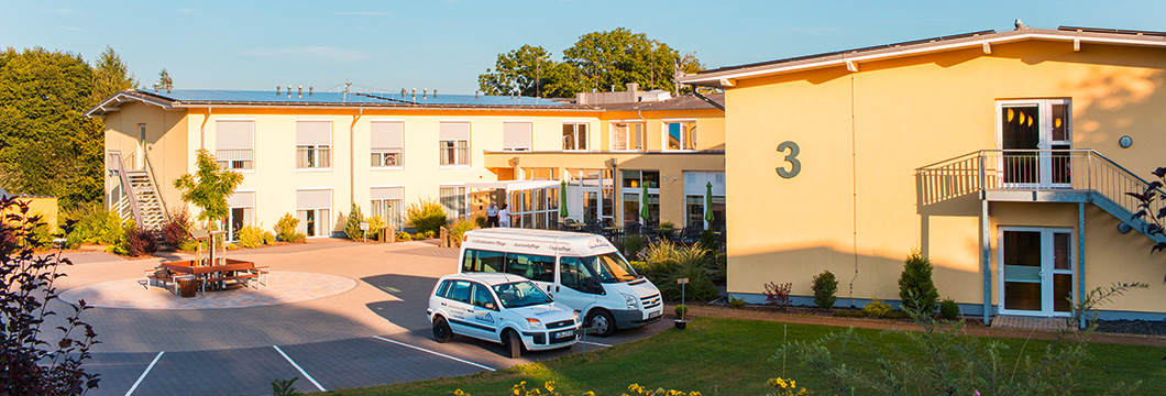In abendlichen Sonnenlicht ist das Seniorenzentrum Driedorf getaucht. Man erkennt den Eingangsbereich und einem davorliegenden kleinen Parkplatz.