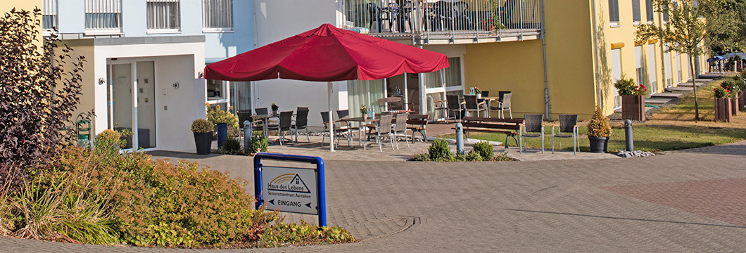 Vor dem Eingangsbereich des Seniorenzentrums laden Sitzgelegenheiten zum Verweilen ein.