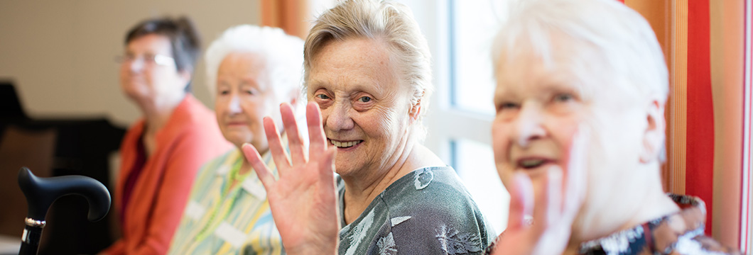 Vier ältere Frauen reden und lachen miteinander
