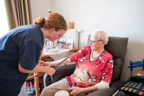 Pflegekraft bei der Blutdruckmessung