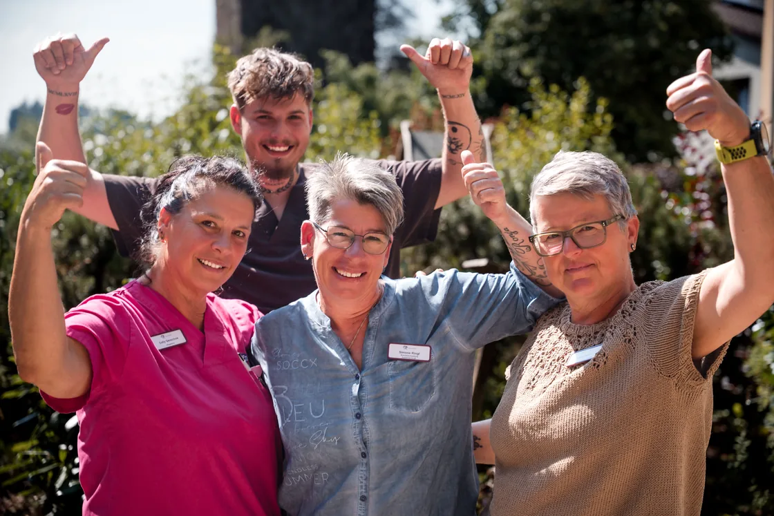 Team des Haus des Lebens im Garten mit Daumen hoch